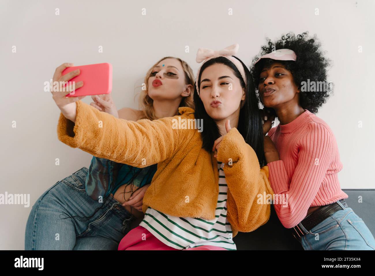 Amis cliquant selfie avec téléphone intelligent à la maison Banque D'Images