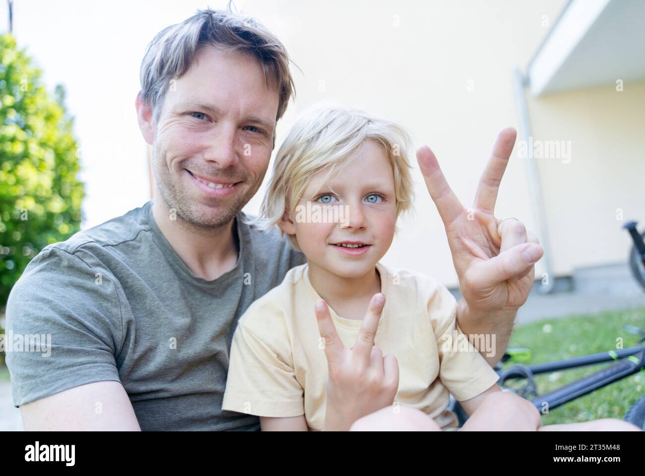 Heureux père et fils montrant le geste de signe de paix Banque D'Images