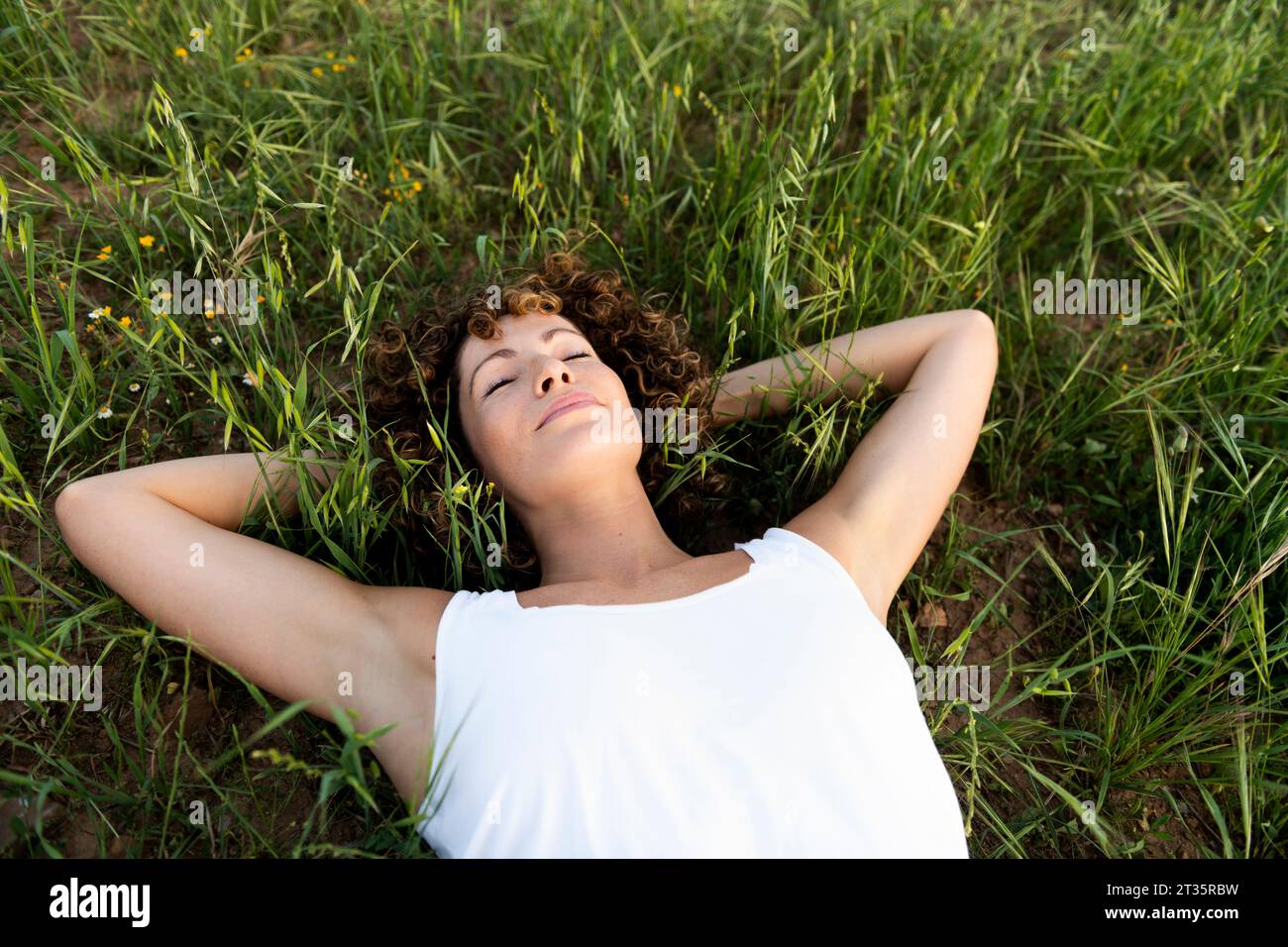 Femme couchée sur l'herbe avec les yeux fermés Banque D'Images