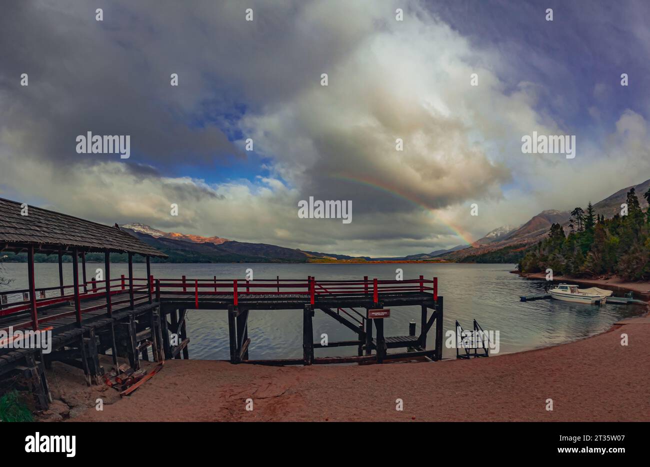 Bel arc-en-ciel sur le lac avec des montagnes en arrière-plan Banque D'Images