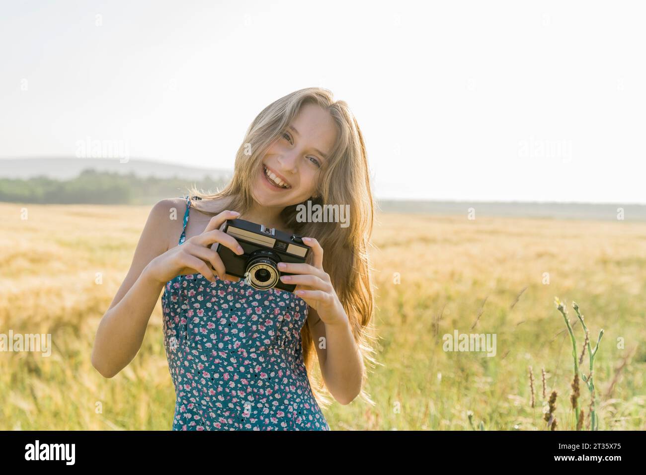 Fille souriante avec caméra au champ Banque D'Images