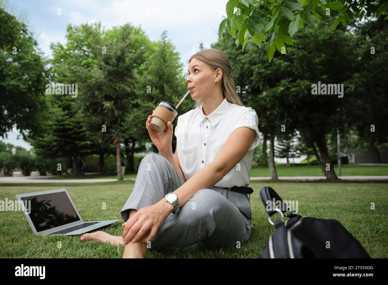 Femme d'affaires réfléchie buvant du café dans le parc de bureaux Banque D'Images