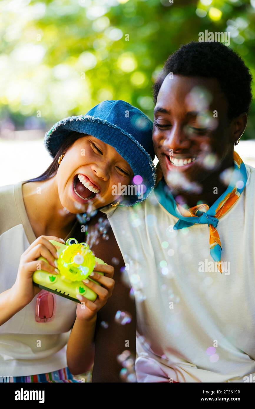 Homme heureux avec femme tenant la caméra dans le jardin Banque D'Images