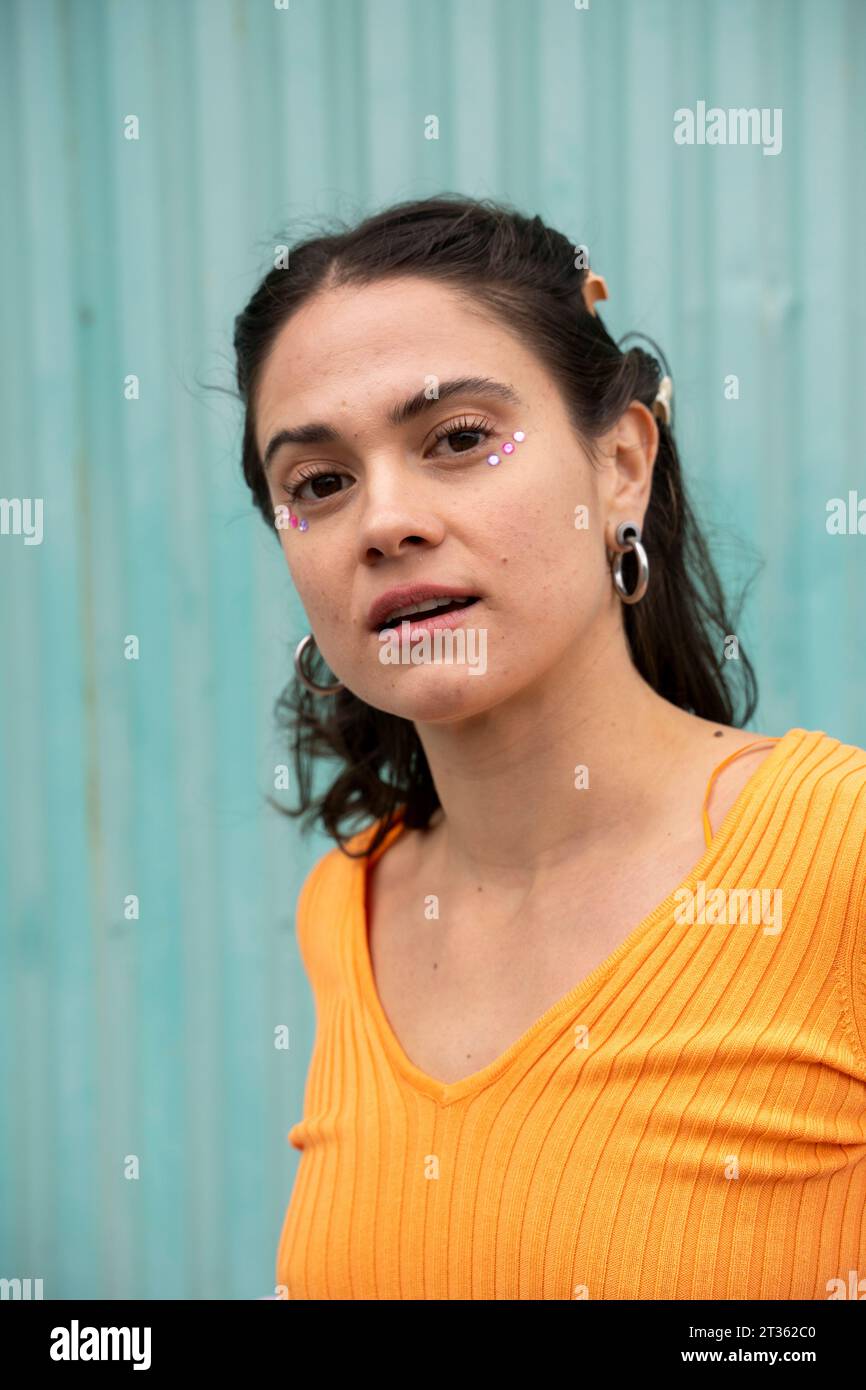 Femme avec des autocollants sous les yeux devant la porte bleue de l'obturateur Banque D'Images