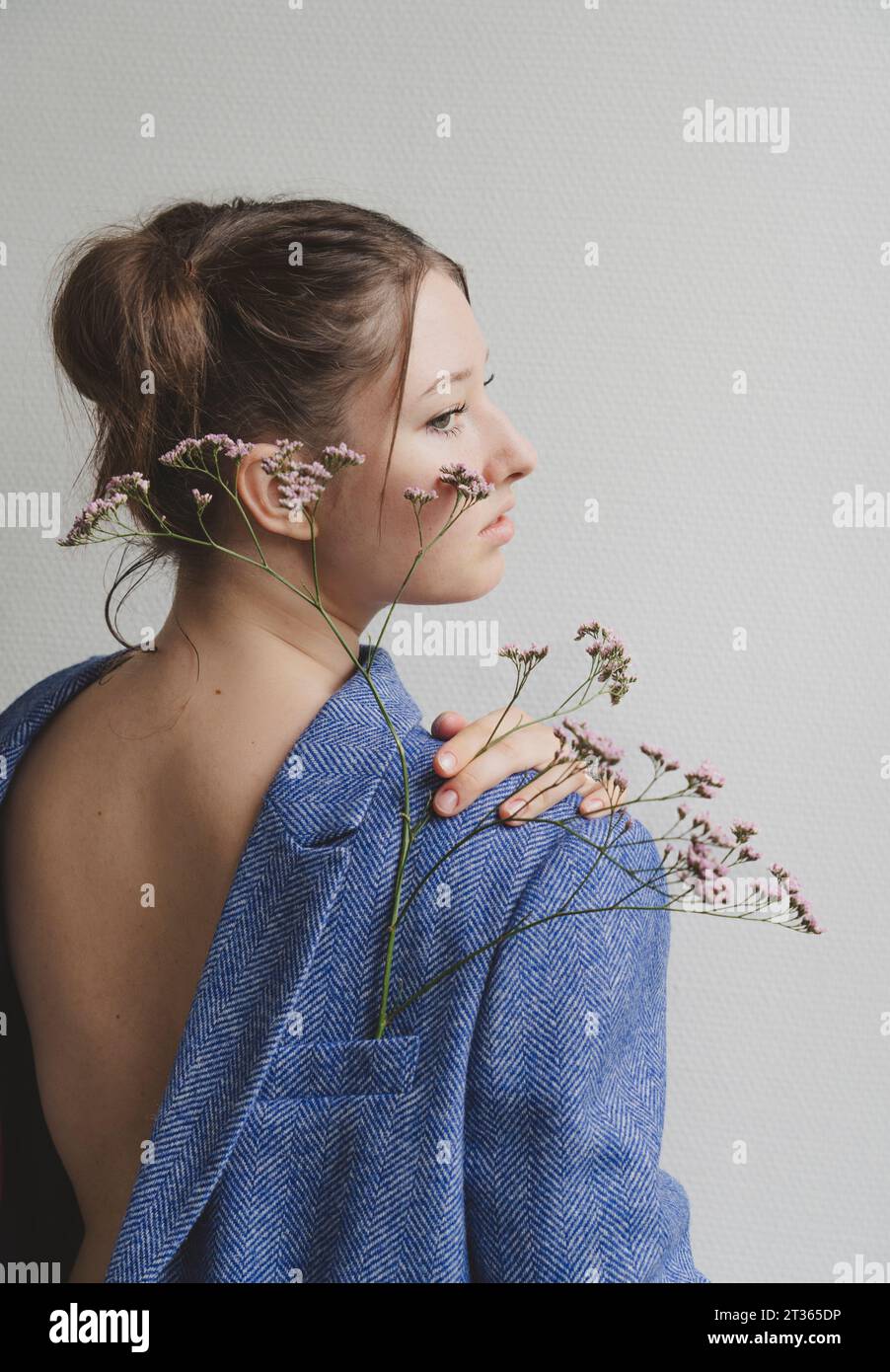 Adolescente portant un blazer à l'envers avec des fleurs dans la poche Banque D'Images