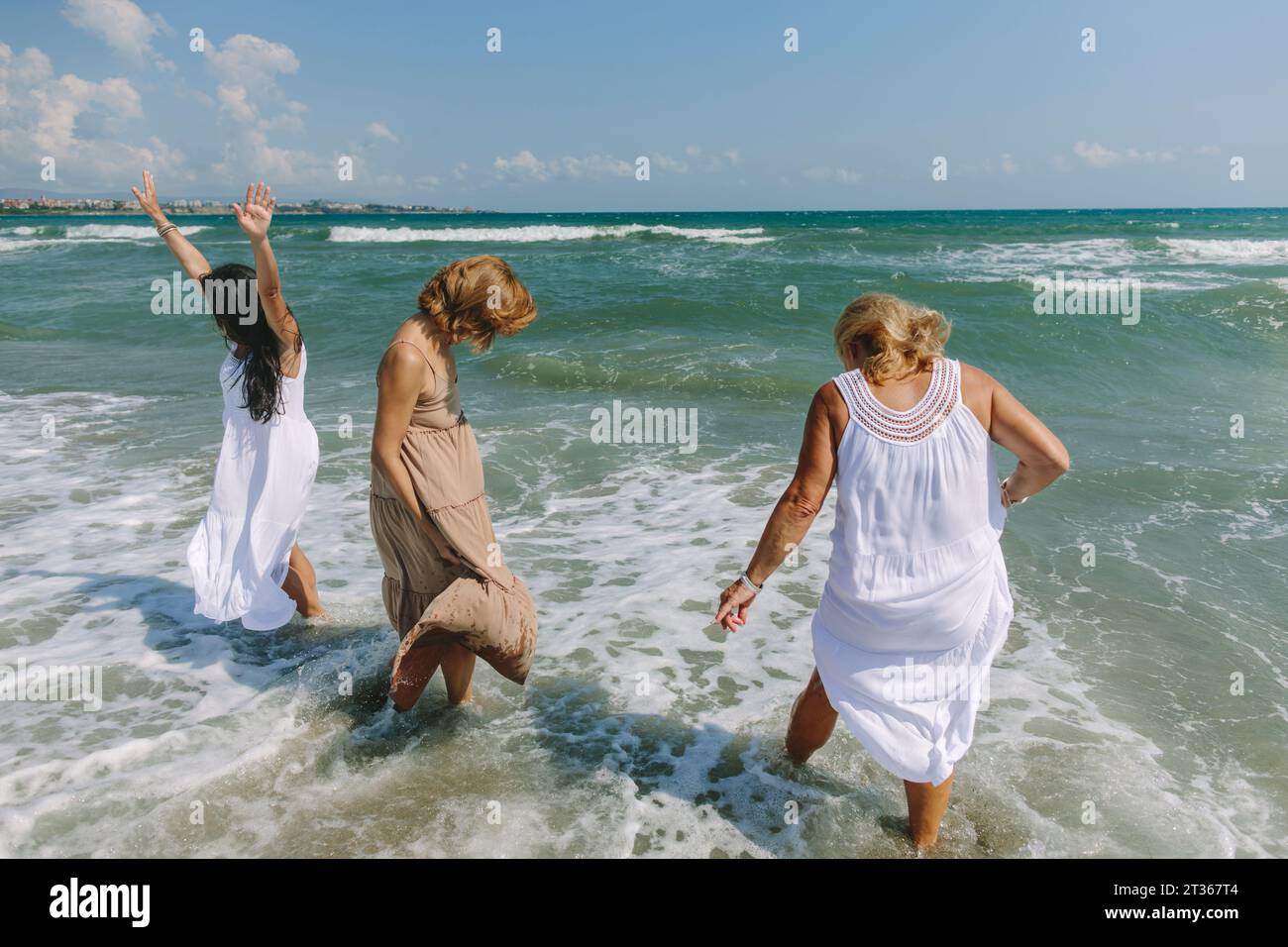 Amis insouciants profitant en mer à la plage Banque D'Images