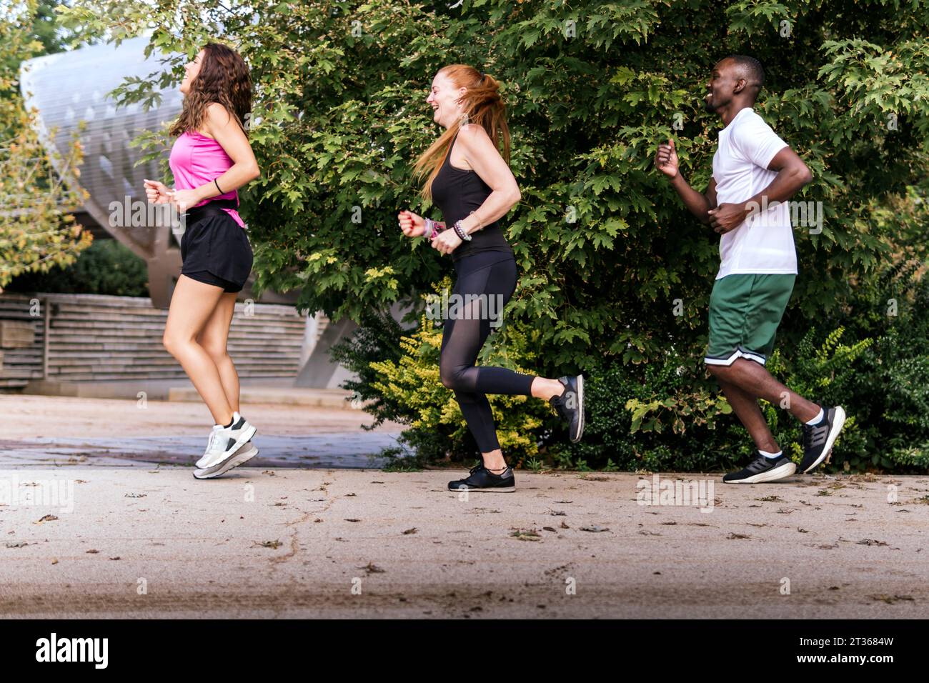 Homme courant avec des femmes sur le sentier au parc Banque D'Images