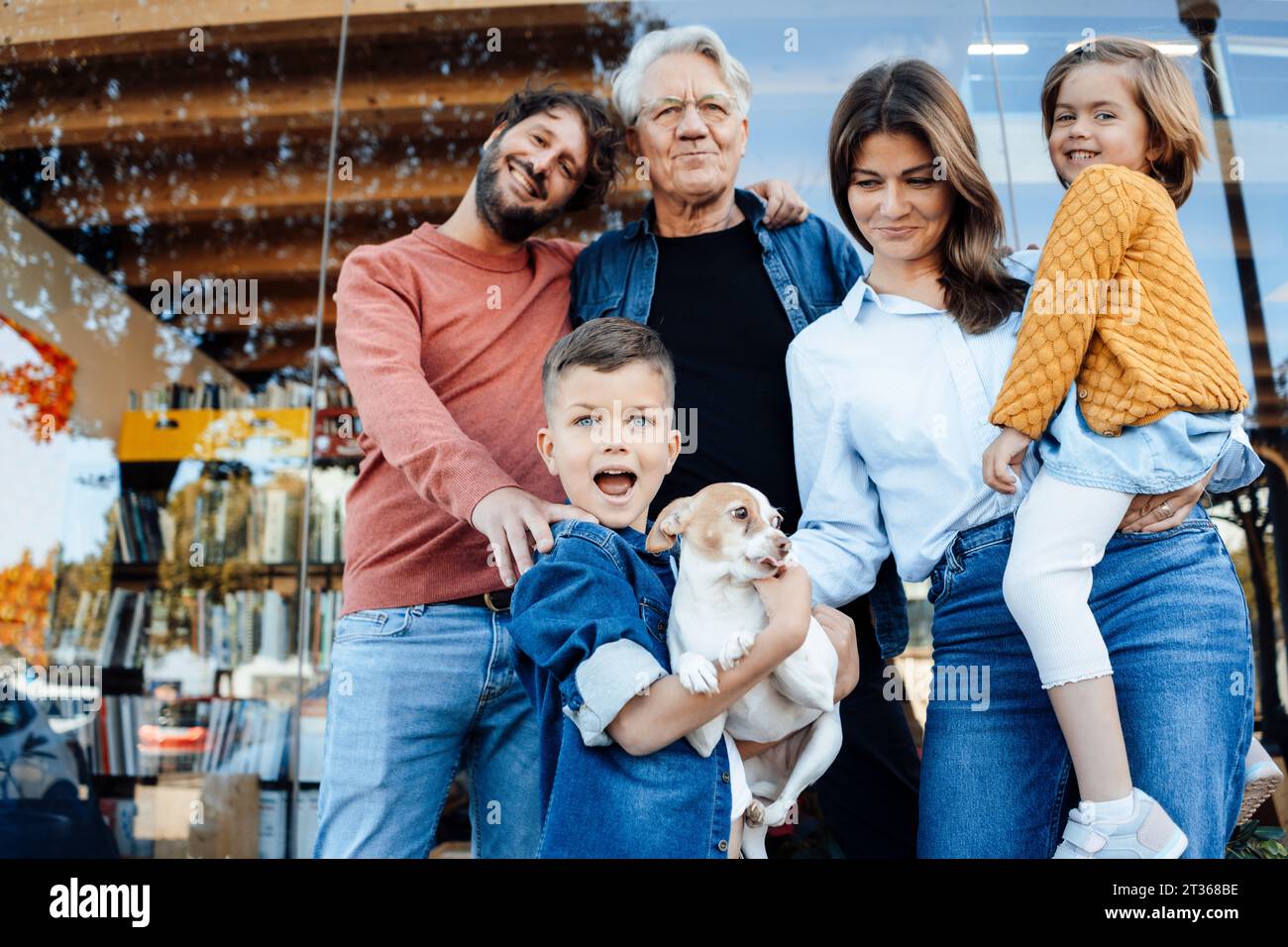 Famille heureuse avec animal de compagnie devant le mur Banque D'Images