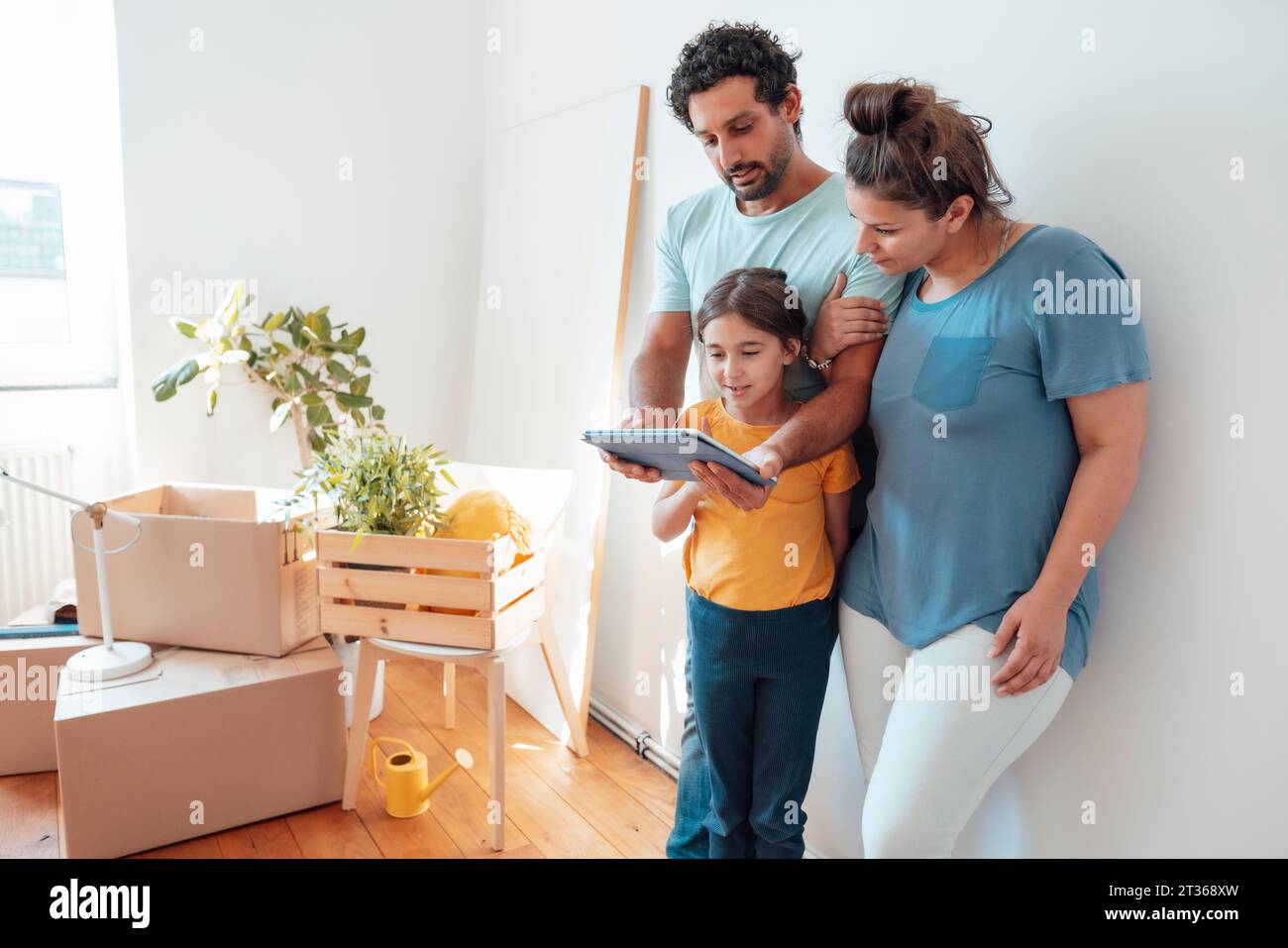 Parents avec fille utilisant un PC tablette à la maison Banque D'Images