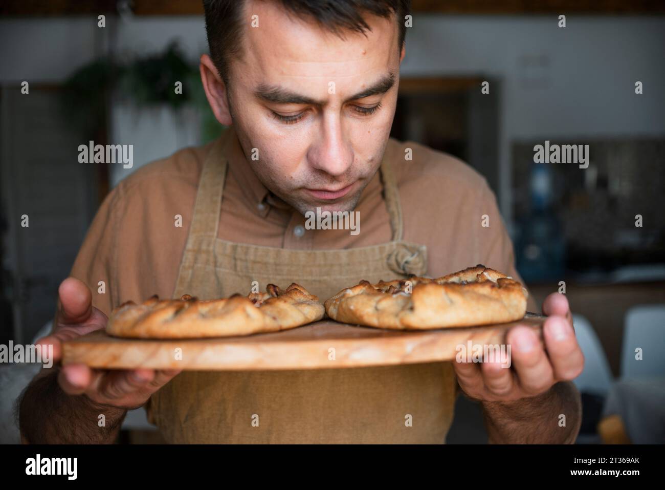 Homme sentant la tarte cuite sur une planche à découper Banque D'Images