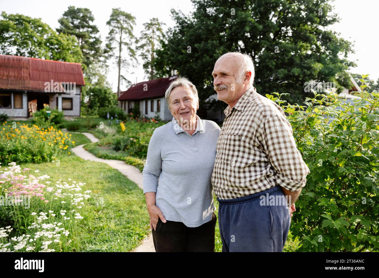 Heureux couple senior debout dans le jardin Banque D'Images