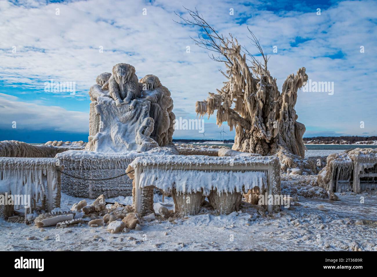 Formations de glace étranges sur le monument, arbre et bancs sur le quai du lac Érié, Canada, jour après tempête hivernale, ciel orageux Banque D'Images