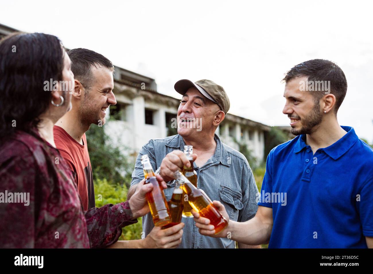 Des amis qui toastent des bouteilles de bière Banque D'Images