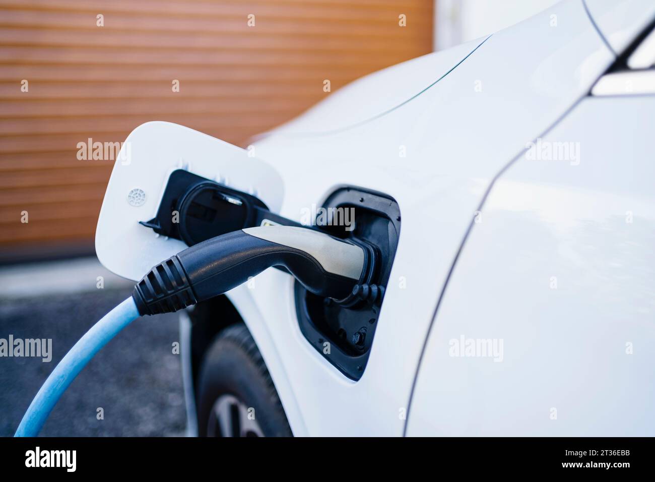 Cordon d'alimentation chargeant la voiture électrique à la gare Banque D'Images