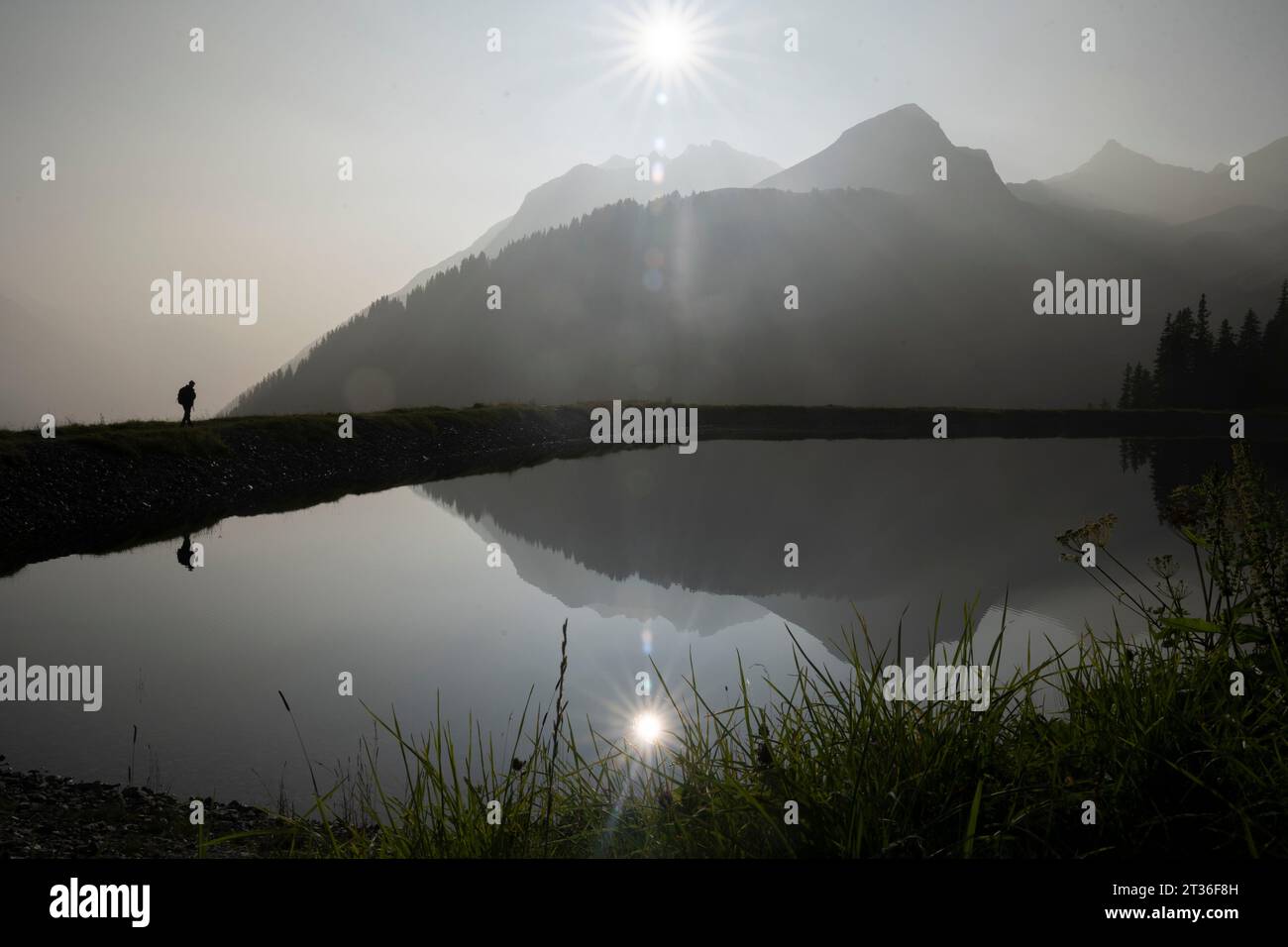 Silhouette homme randonnée près du lac Banque D'Images