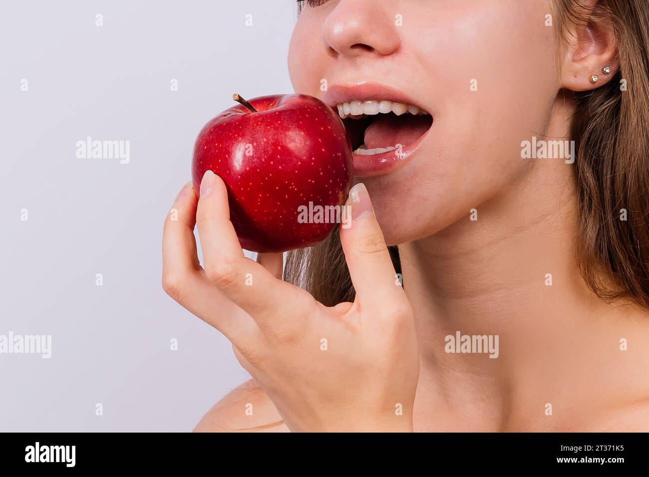 Petit déjeuner du matin. Femme avec des dents saines tenant des pommes sur un fond gris isolé. Banque D'Images