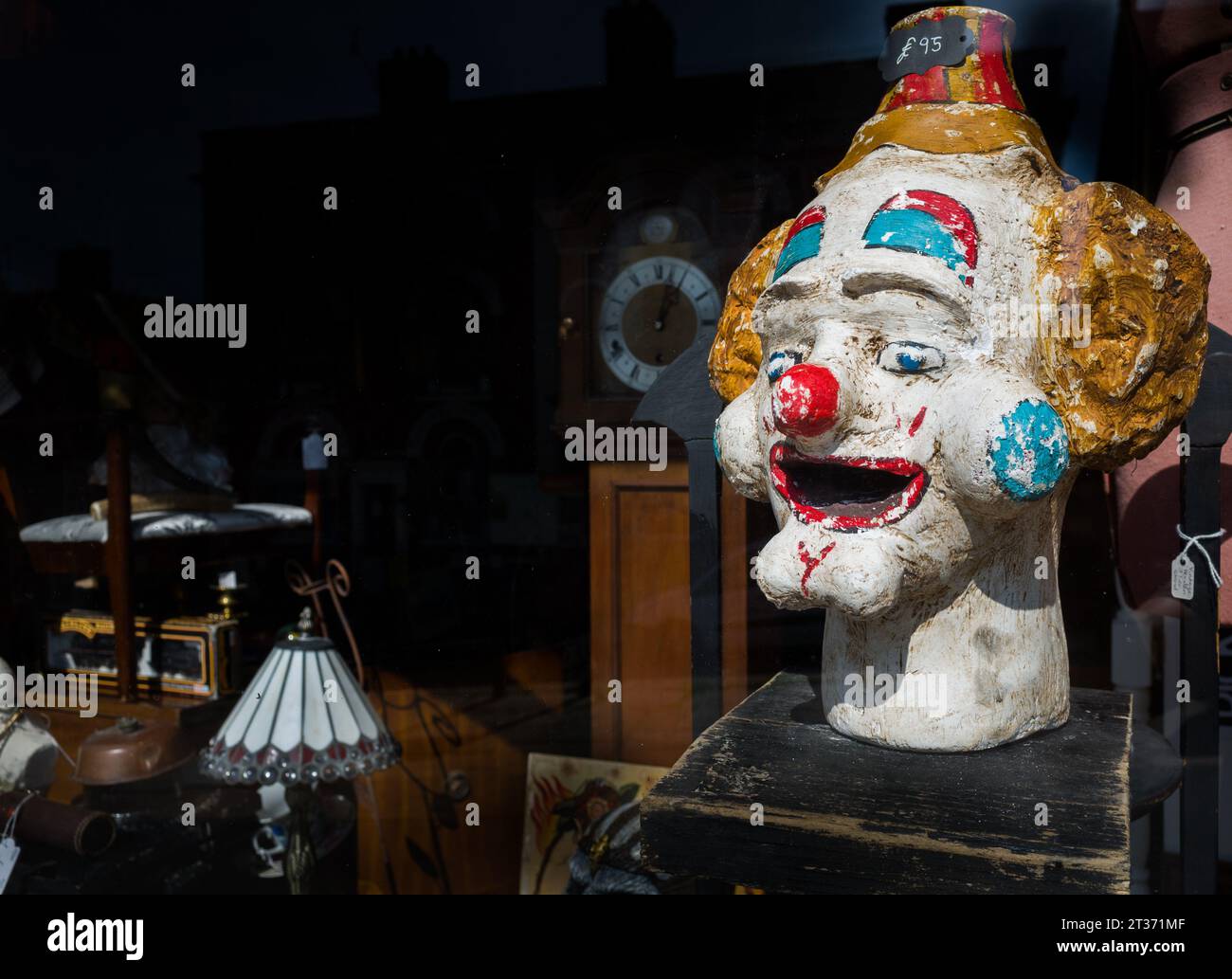 Vieille tête de clown rétro à vendre dans une vitrine de magasin d'antiquités. Banque D'Images