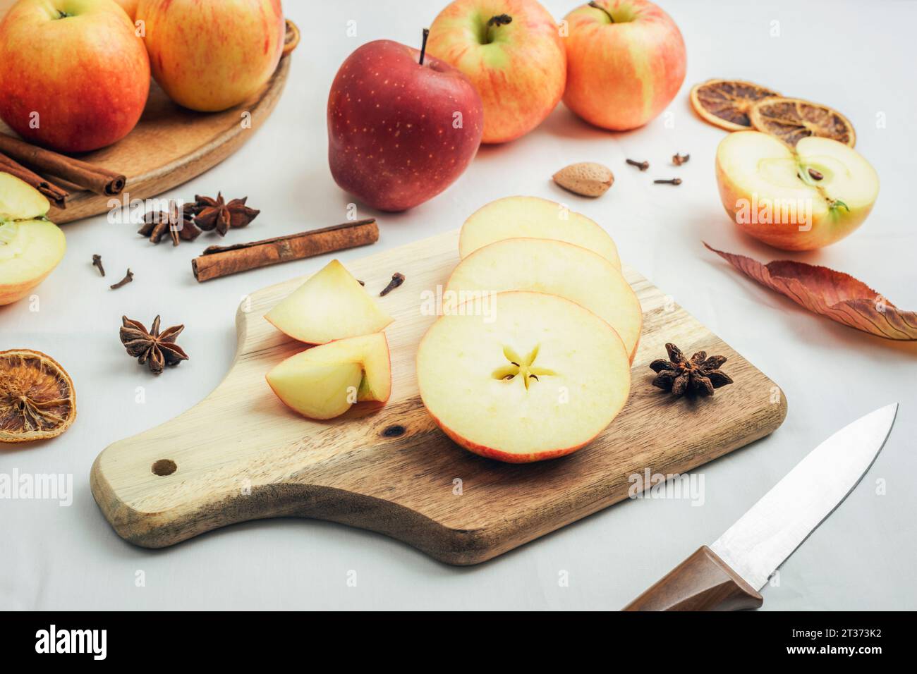 Pommes mûres fraîches sur la planche à découper sur fond de table blanc. . Récolte d'automne, ingrédients pour le concept de tarte aux pommes. Vue de dessus. Banque D'Images