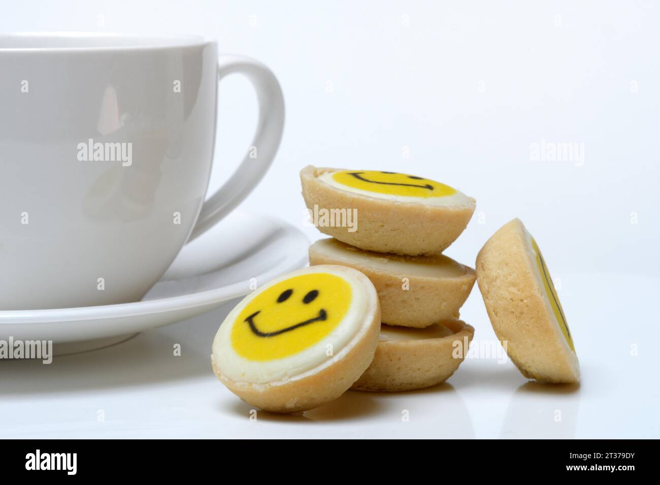 Pâtisserie avec visage souriant et tasse à café, symbole Banque D'Images