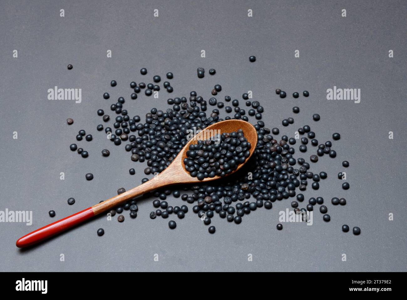 Lentilles béluga noires avec cuillère en bois Banque D'Images