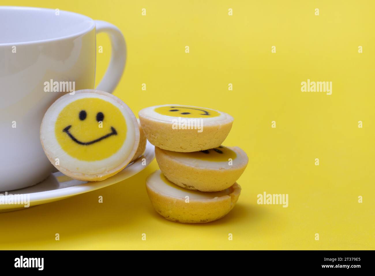 Pâtisserie avec visage souriant et tasse à café, symbole Banque D'Images