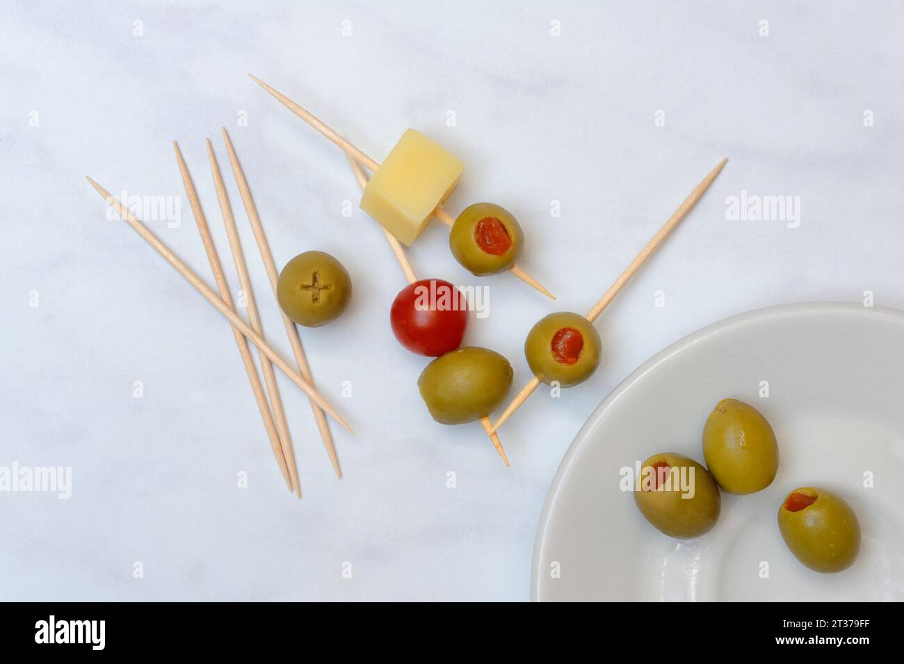 Olives farcies sur cure-dents, olives vertes, tomates et cubes de fromage Banque D'Images