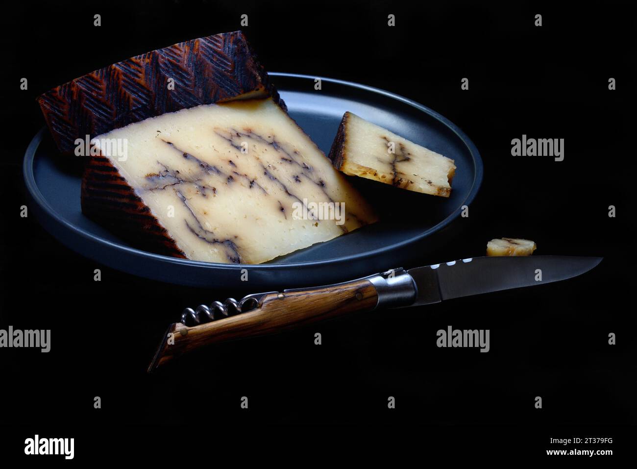 Fromage de brebis à l'ail noir sur plaque avec couteau, Espagne Banque D'Images