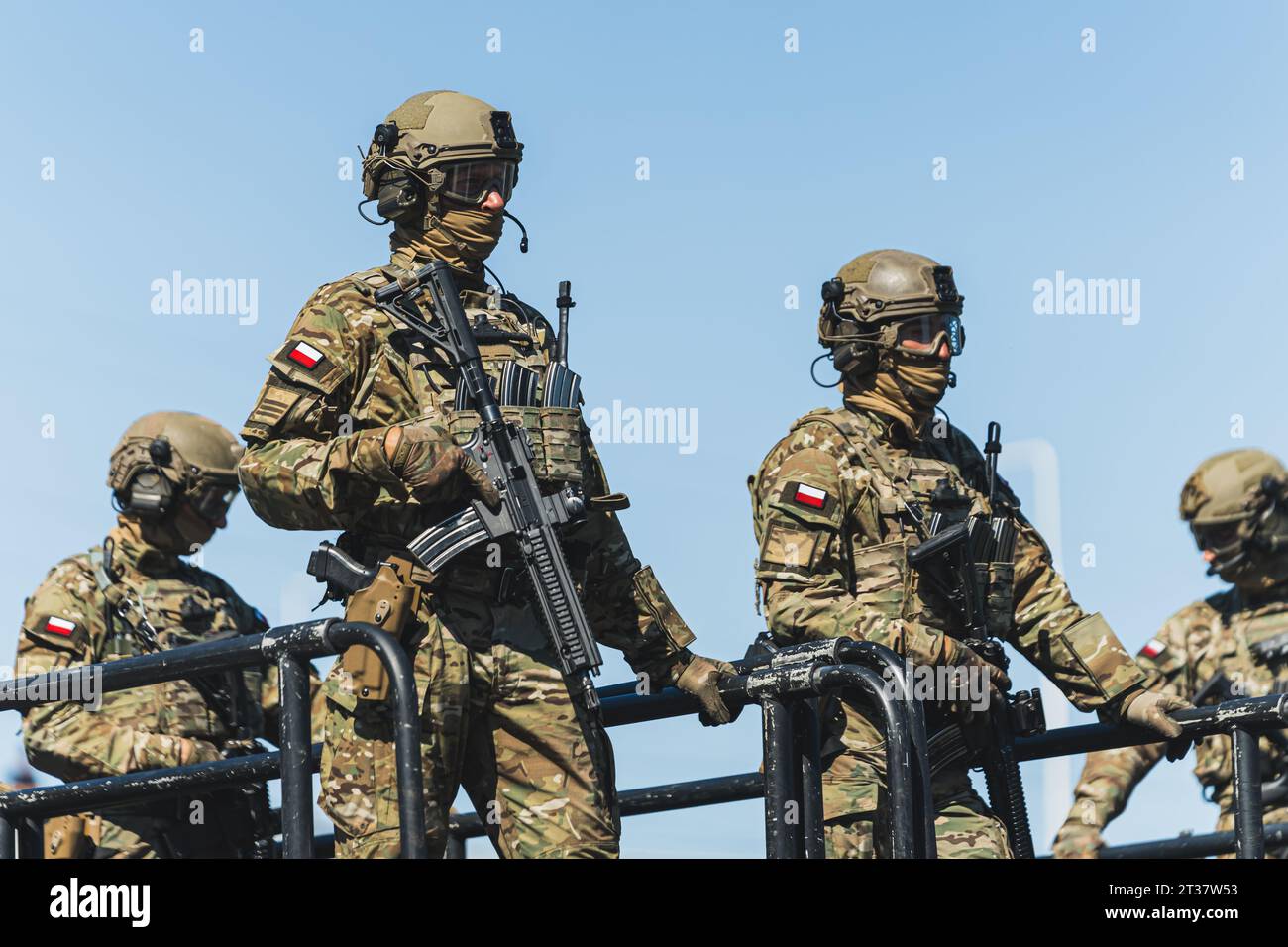 16.08.2023 Varsovie, Pologne. Escouade des forces spéciales sur un véhicule à échelle. Les gens travaillant comme concept militaire. Quatre soldats armés en camouflage et avec des drapeaux polonais sur les bras pendant un défilé. Photo de haute qualité Banque D'Images