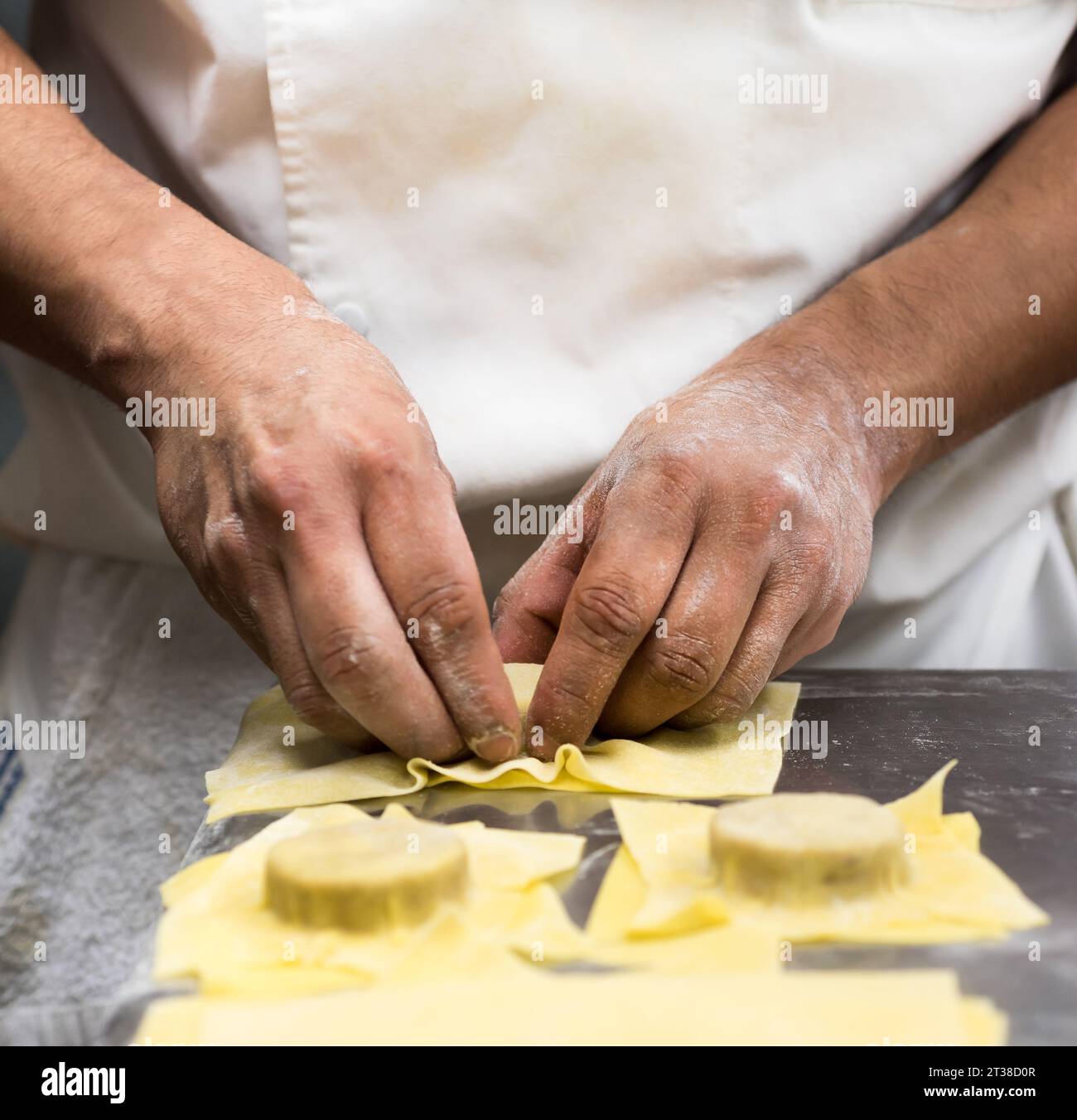 Le chef mains dans la cuisine préparant des pâtes Banque D'Images