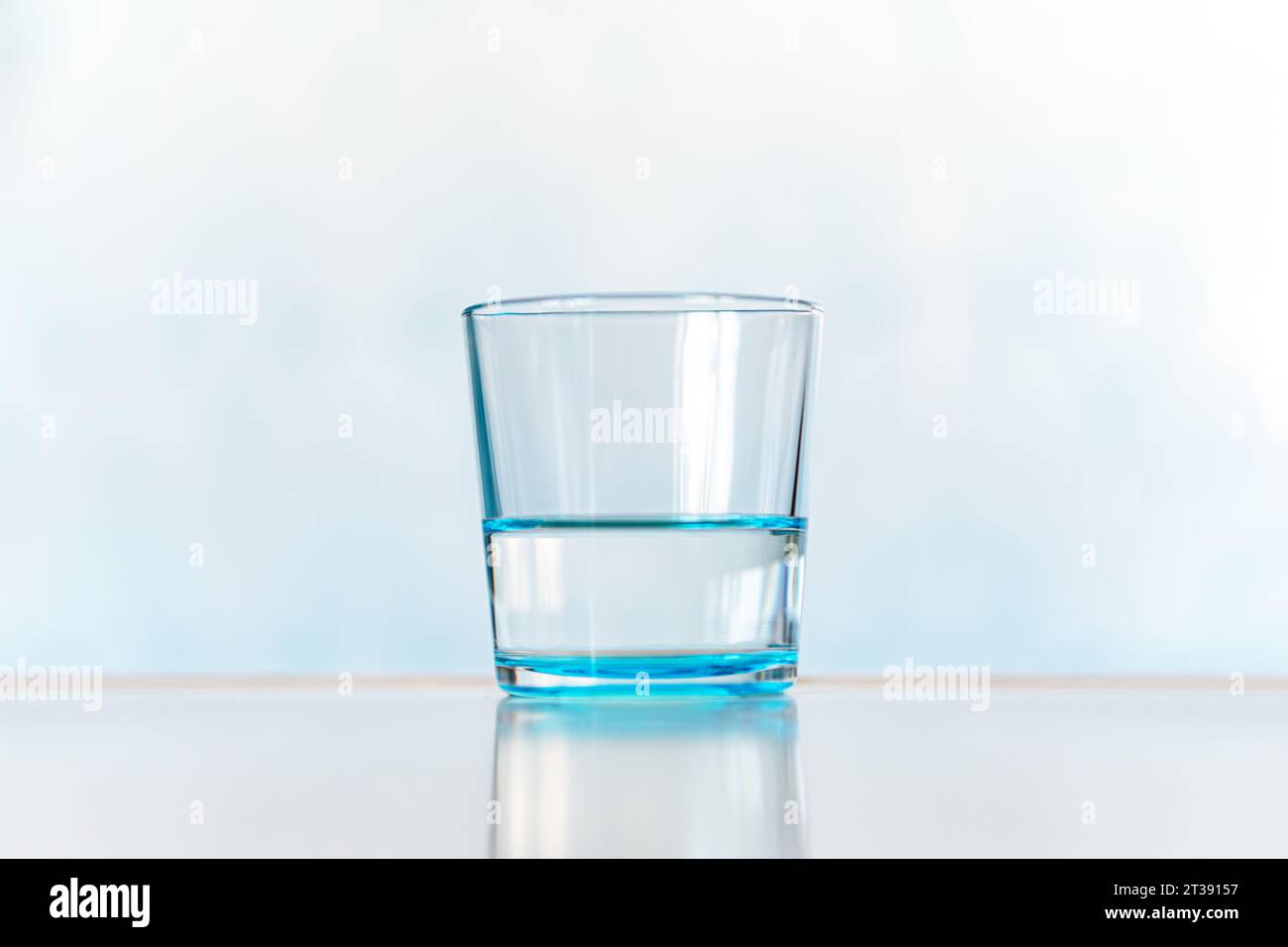 Clair et verre d'eau. verre bleu avec de l'eau claire sur un fond bleu Banque D'Images