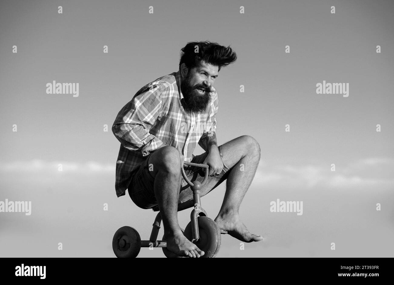 Portrait d'un homme barbu cycliste, hipster fou s'amuser avec le vélo à l'extérieur. Banque D'Images