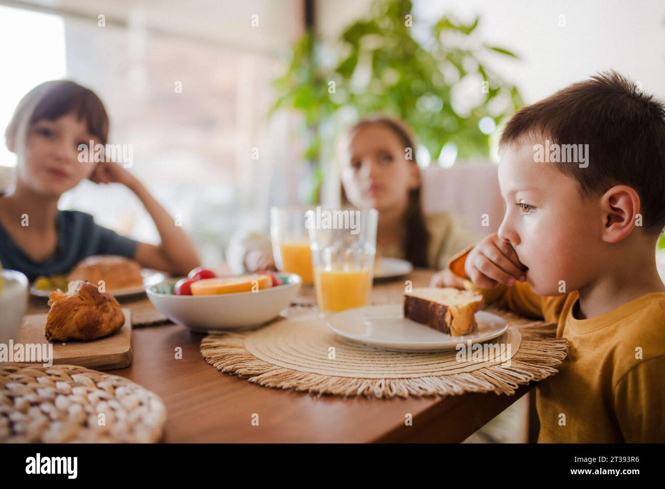 Frères et sœurs prenant le petit déjeuner le matin, avant l'école. Retour à l'école, petit déjeuner maison. Importance du petit déjeuner avant l'école. Banque D'Images