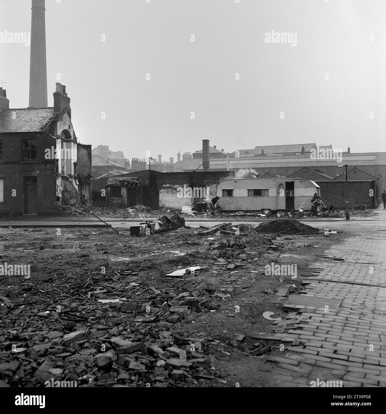 Famille de voyageurs et leur caravane sur la friche adjacente à des maisons démolies et des usines pendant le nettoyage des bidonvilles de St ann's, Nottingham. 1969-1972 Banque D'Images