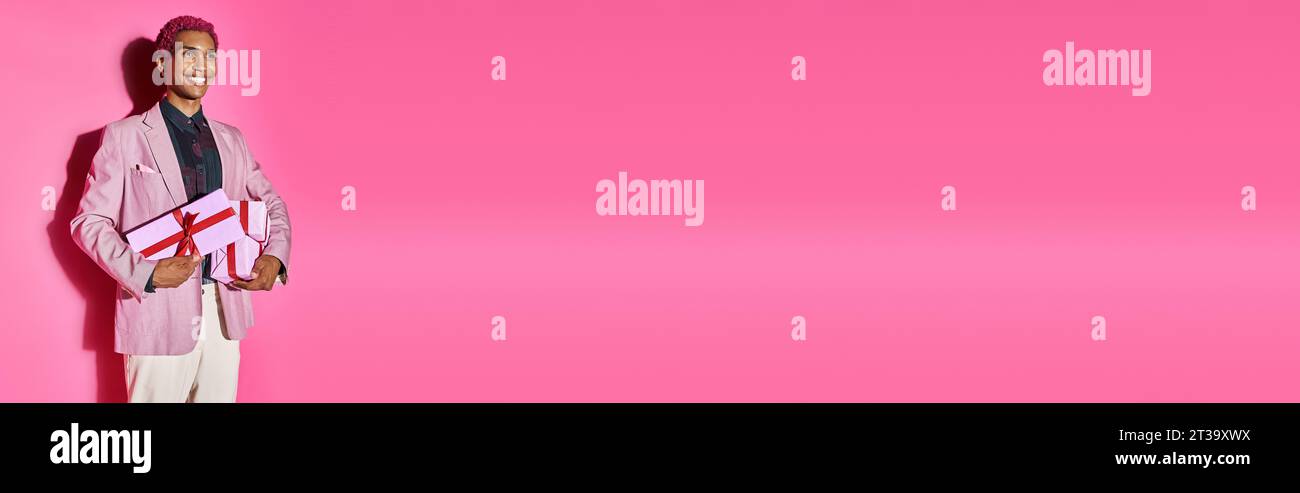 jolly african american modèle masculin dans une tenue élégante vivante posant avec des cadeaux dans ses mains, bannière Banque D'Images