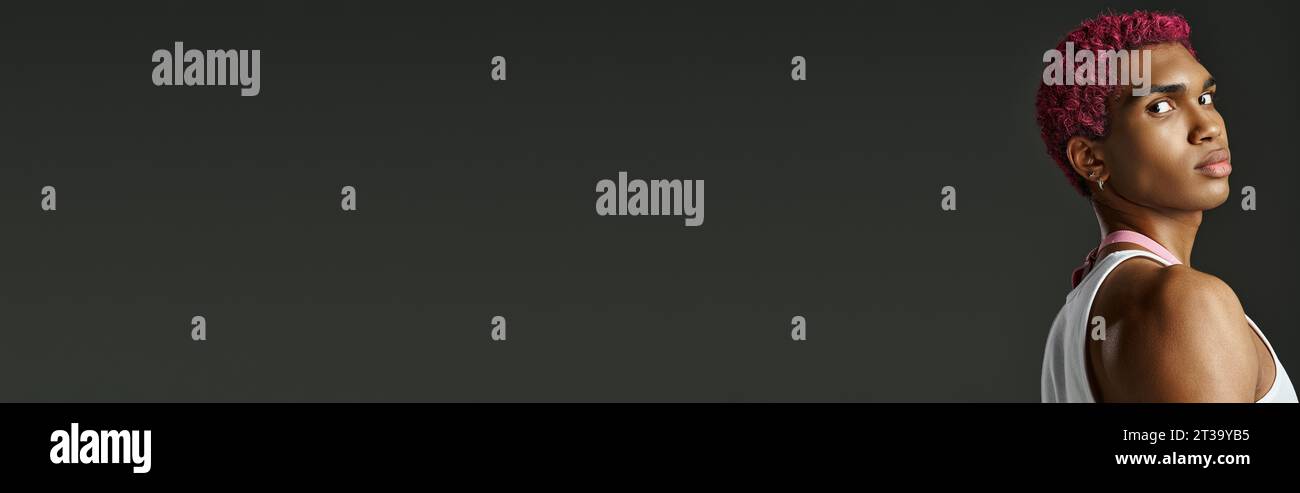 beau modèle masculin élégant regardant charismatiquement à la caméra sur fond gris, mode, bannière Banque D'Images