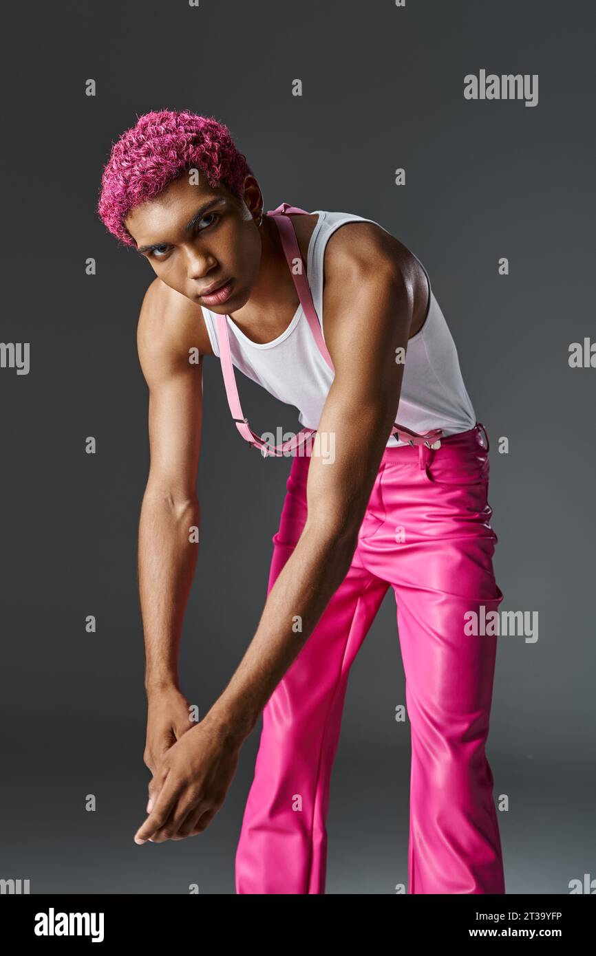 modèle masculin tendance avec les cheveux roses légèrement penchés vers l'avant et regardant l'appareil photo, la mode et le style Banque D'Images