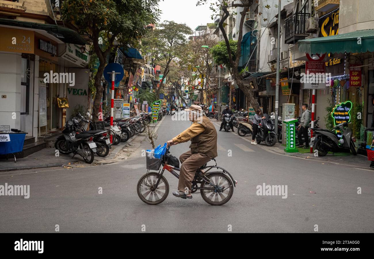 Un vieil homme vietnamien fait du vélo à Hang bac, dans le vieux quartier de Hanoi, au Vietnam Banque D'Images