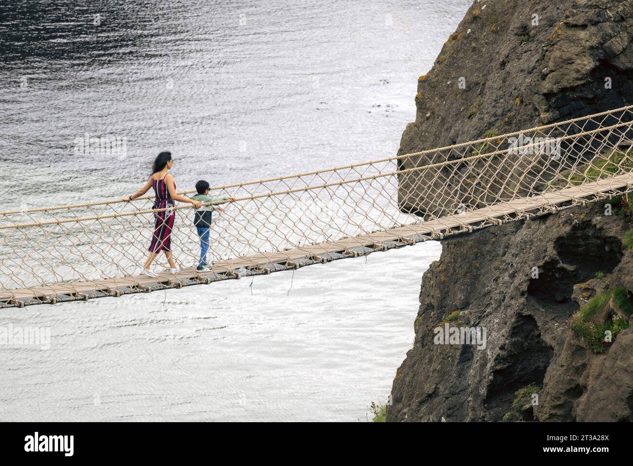 Carrick-a-Rede Rope Bridge, en Irlande du Nord, est un pont de corde de 20 mètres de long enjambant un gouffre de 30 mètres, reliant le continent à la minuscule île de C. Banque D'Images