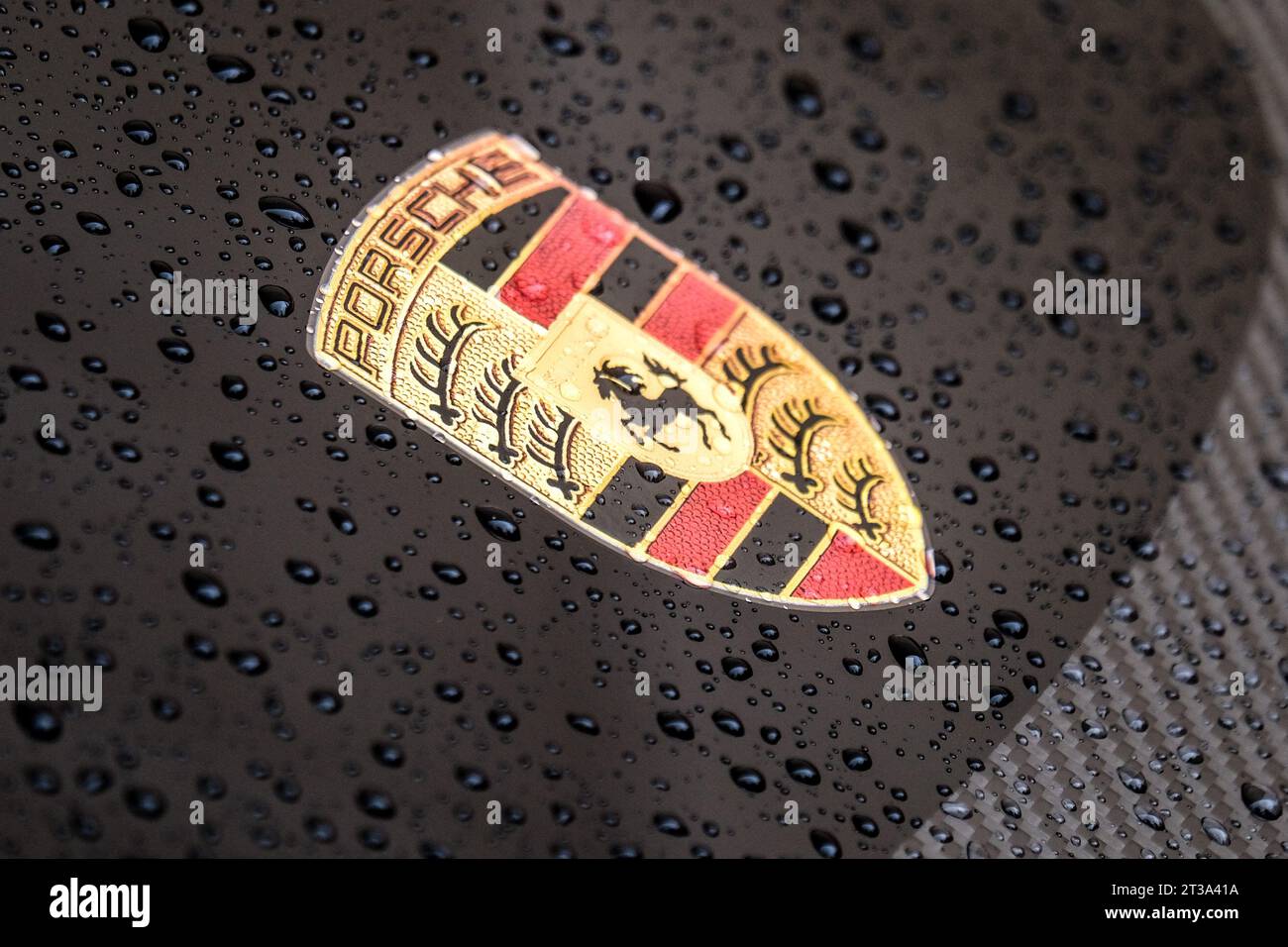 Logo Porsche sur une voiture noire avec des gouttelettes d'eau. Ferdinand Porsche a fondé la société en 1931 avec des bureaux principaux dans le centre de Stuttgart. Banque D'Images