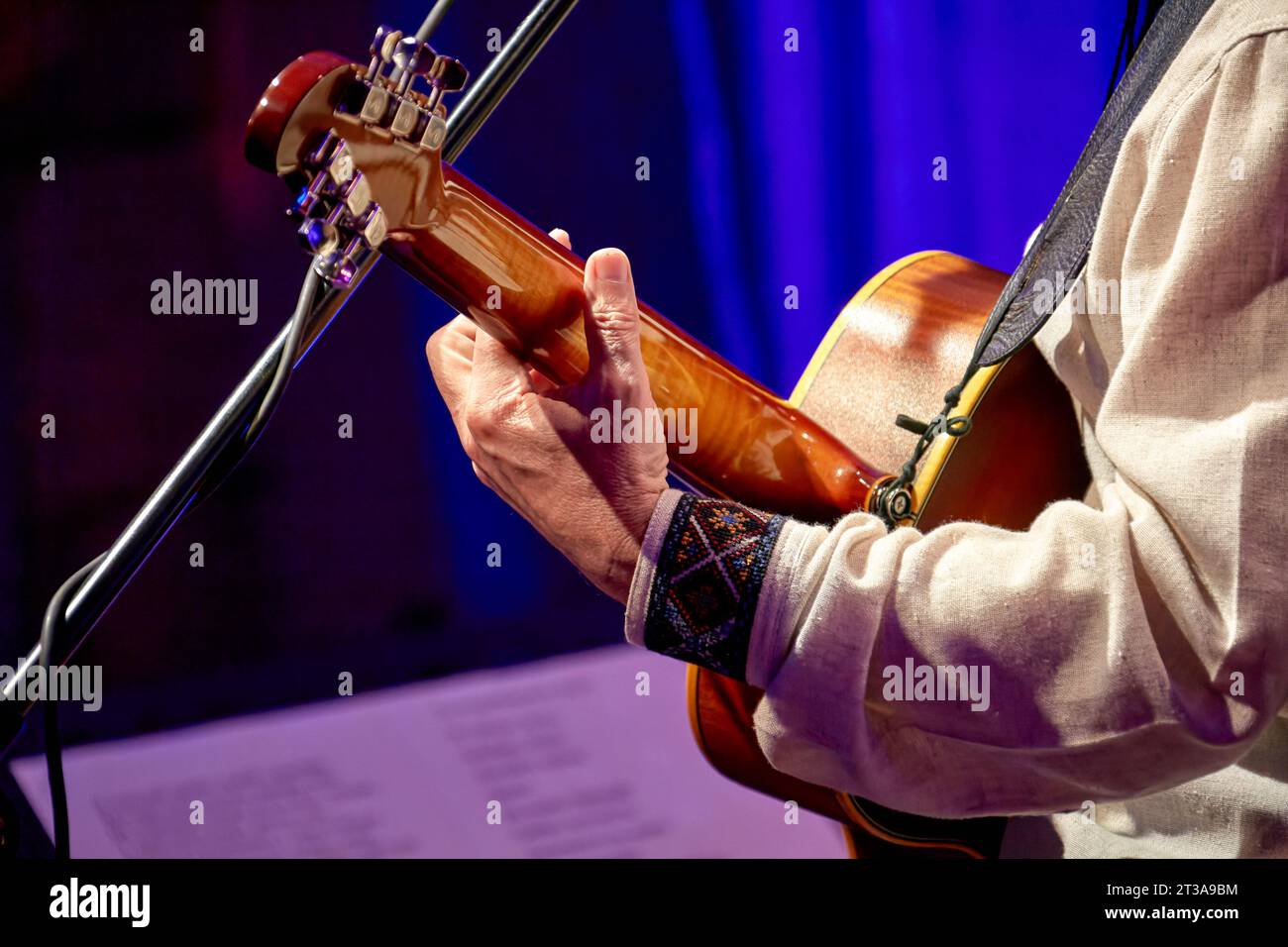 Image d'un homme jouant d'une guitare acoustique devant un microphone Banque D'Images