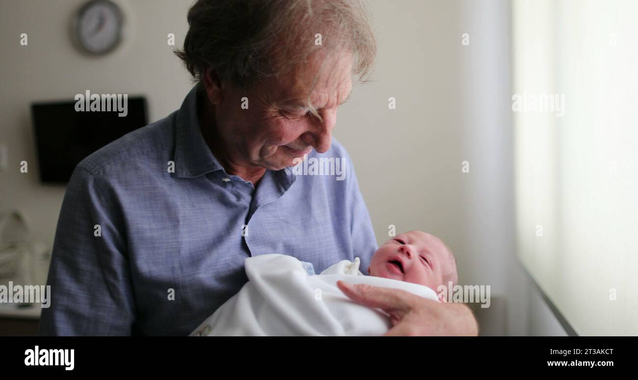 Nouveau-né bébé étant grand-père à côté de la fenêtre de l'hôpital Banque D'Images