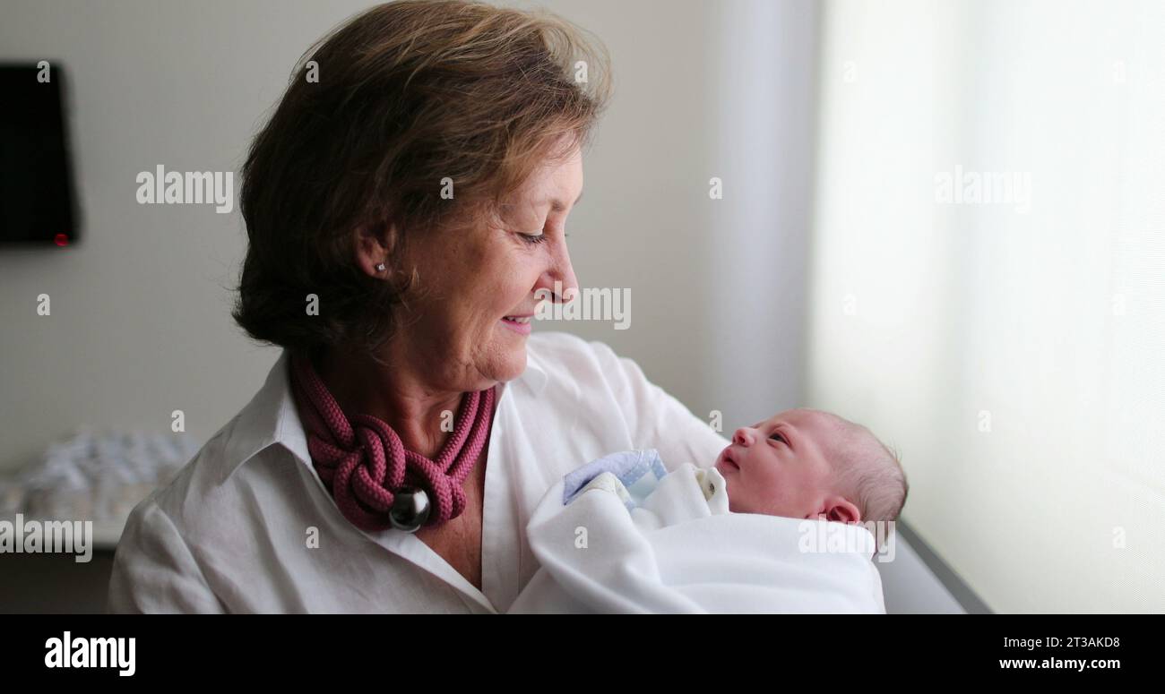 Nouveau-né bébé étant tenu par grand-mère, la vie réelle et authentique Banque D'Images