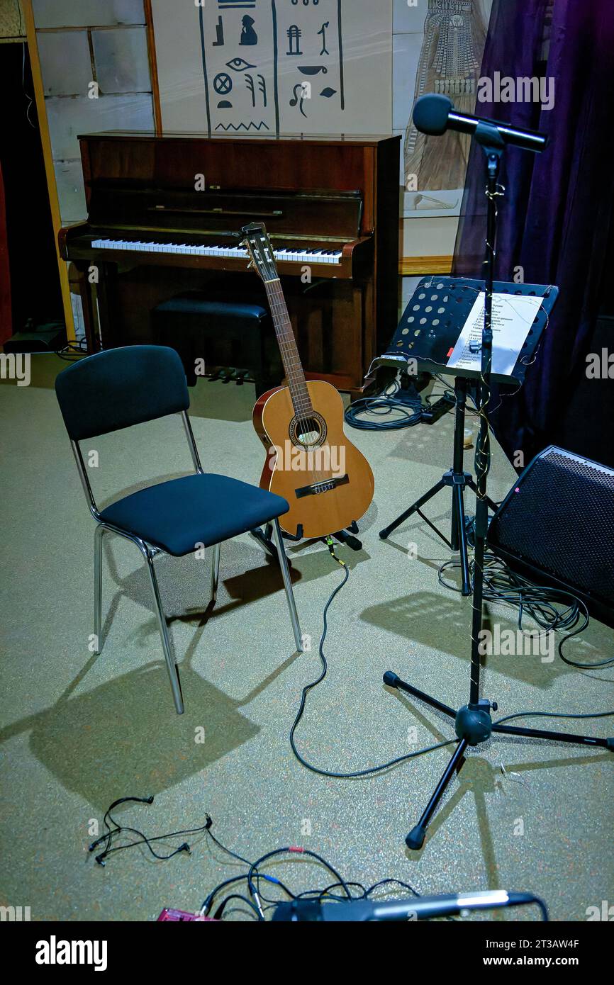 Une image d'une guitare acoustique se tient sur scène près d'un stand de musique Banque D'Images