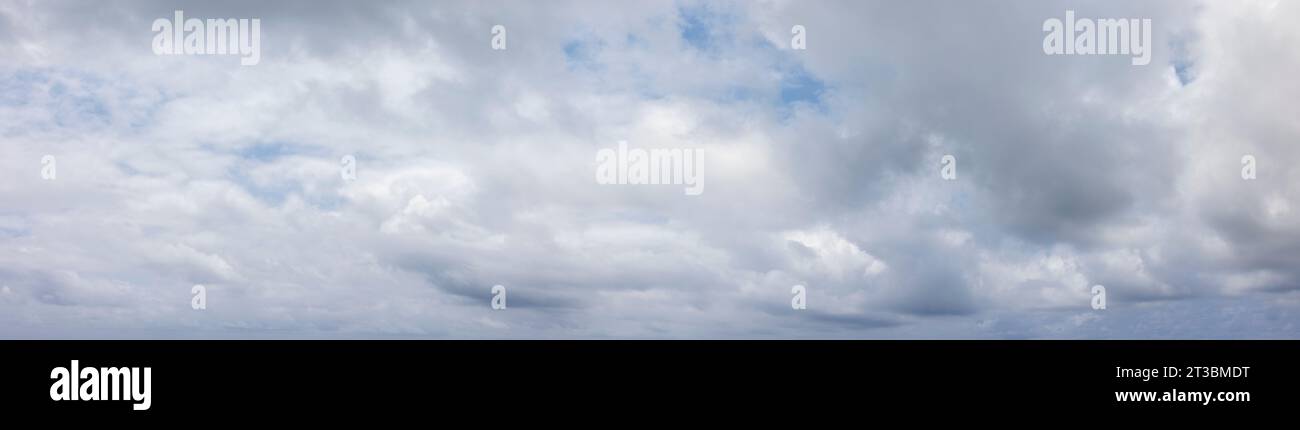 Ciel gris panoramique avec petites taches de ciel bleu Banque D'Images