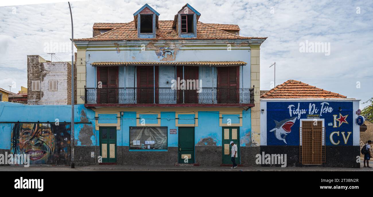 Sao Vicente, Cap-Vert — 21 mai 2023. Un homme passe devant un bâtiment minable qui a besoin d'être réparé. Banque D'Images
