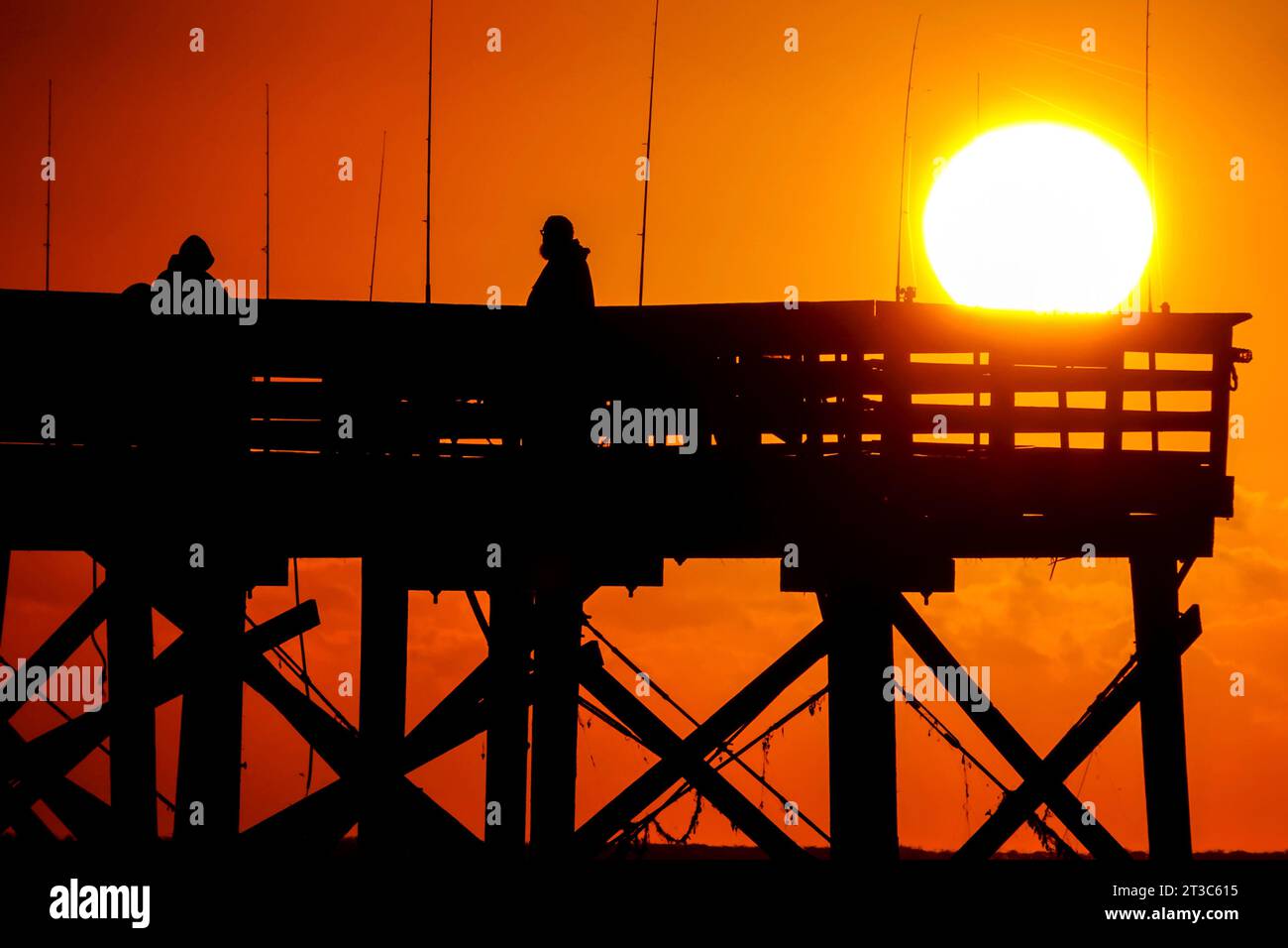 Île de Palms, États-Unis. 24 octobre 2023. Les pêcheurs silhouettés par le lever du soleil attendent que le poisson morde sur la jetée de l'île de Palms, le 24 octobre 2023 à l'île de Palms, en Caroline du Sud. Crédit : Richard Ellis/Richard Ellis/Alamy Live News Banque D'Images