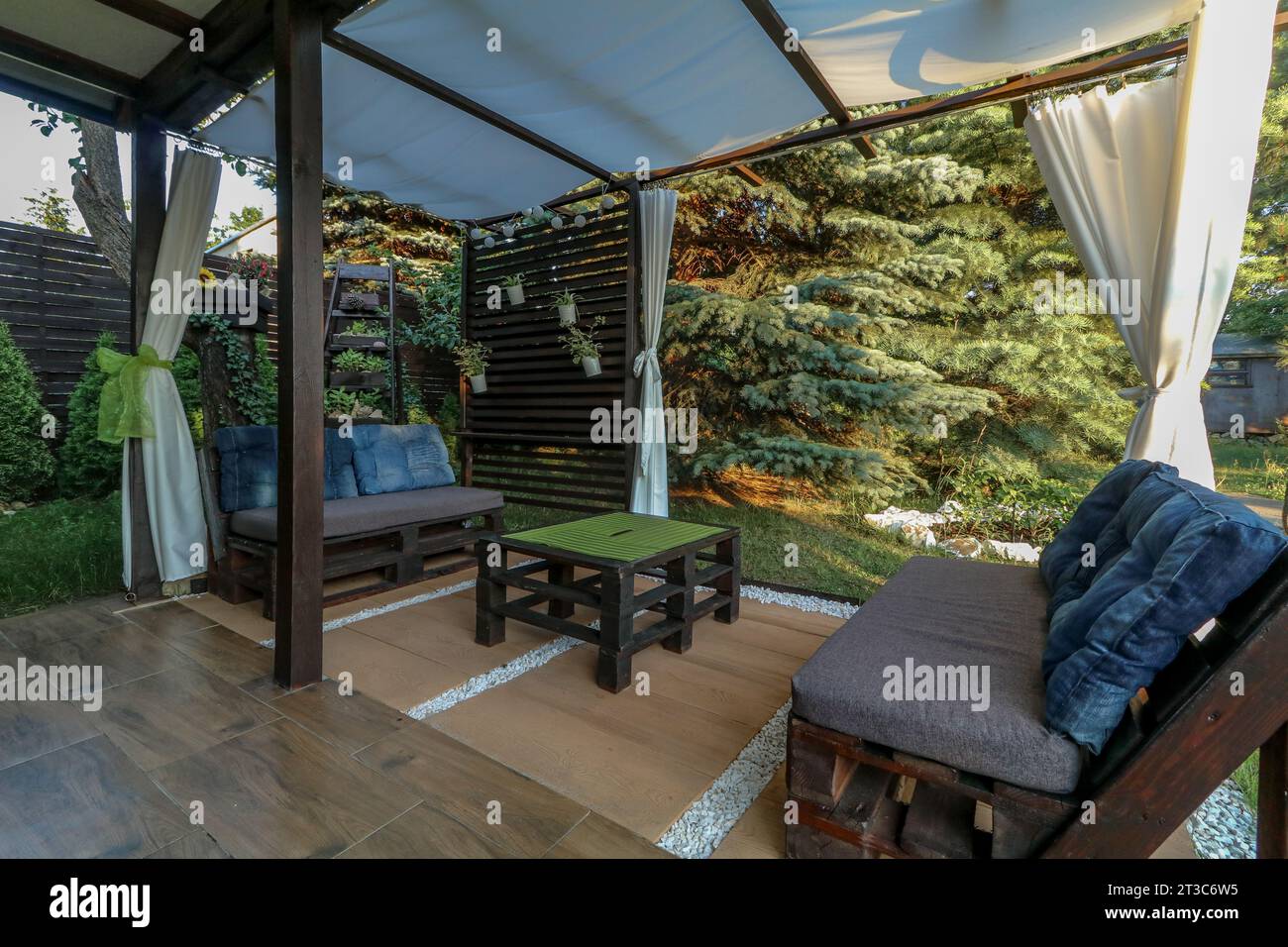 Pose de tuiles de terrasse dans un gazebo sur un terrain de loisirs en été Banque D'Images