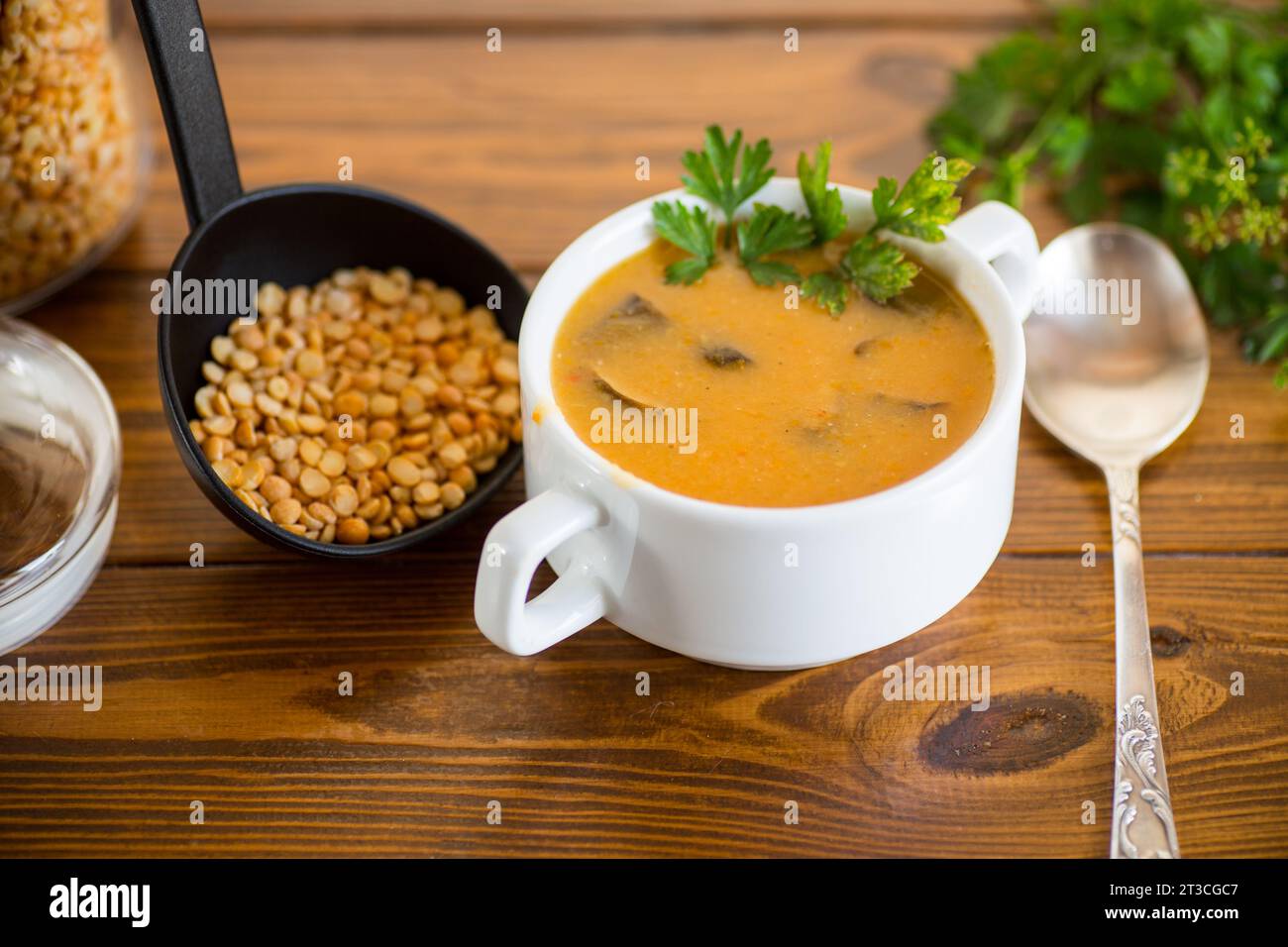 Soupe de purée de pois séchés cuite avec des champignons dans un bol sur une table en bois sombre. Banque D'Images