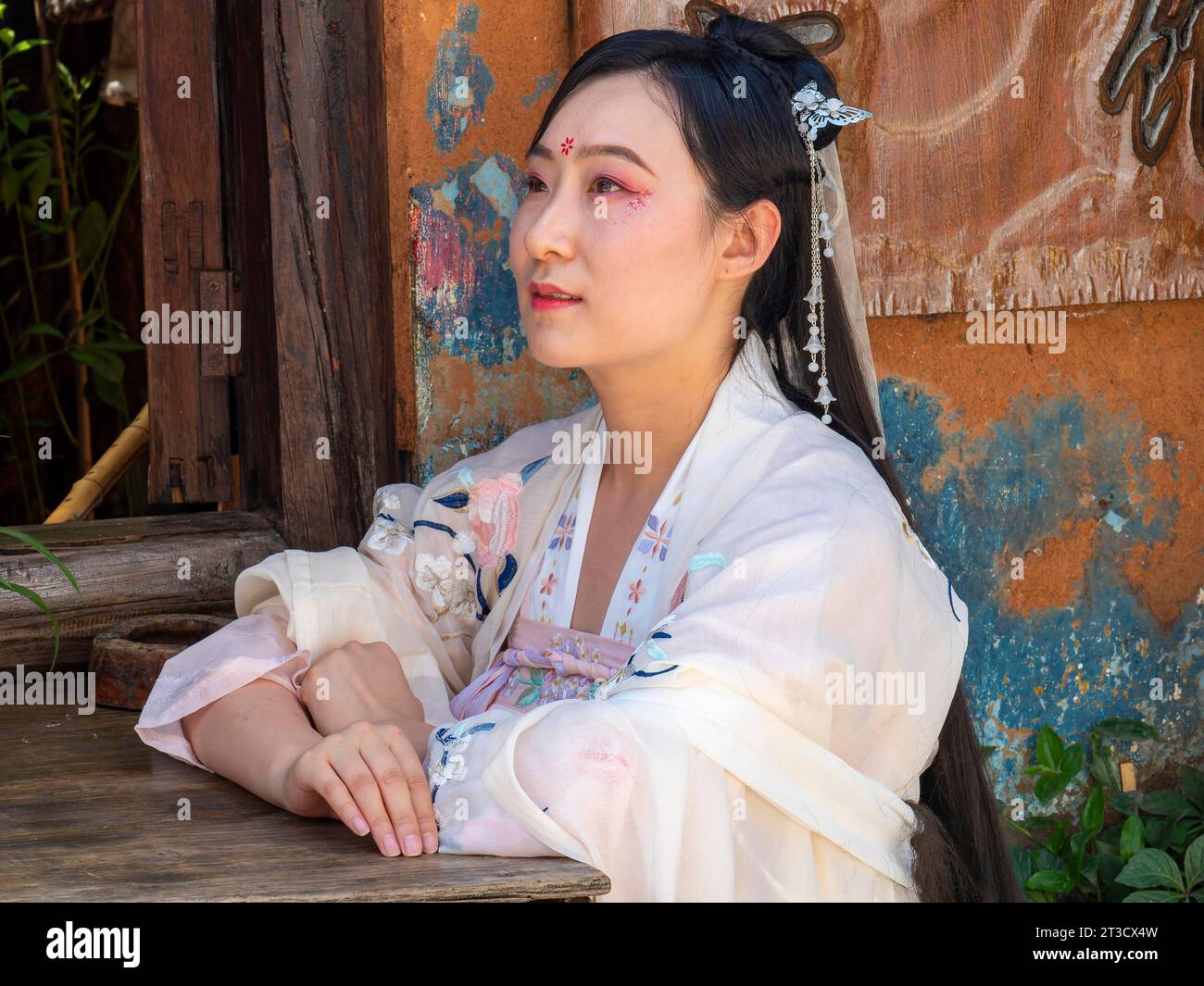 Femme dans la nostalgie chinoise avec vieille robe blanche luxueuse en face de la vieille maison, vieille ville historique Dali, Yunnan, Chin Banque D'Images