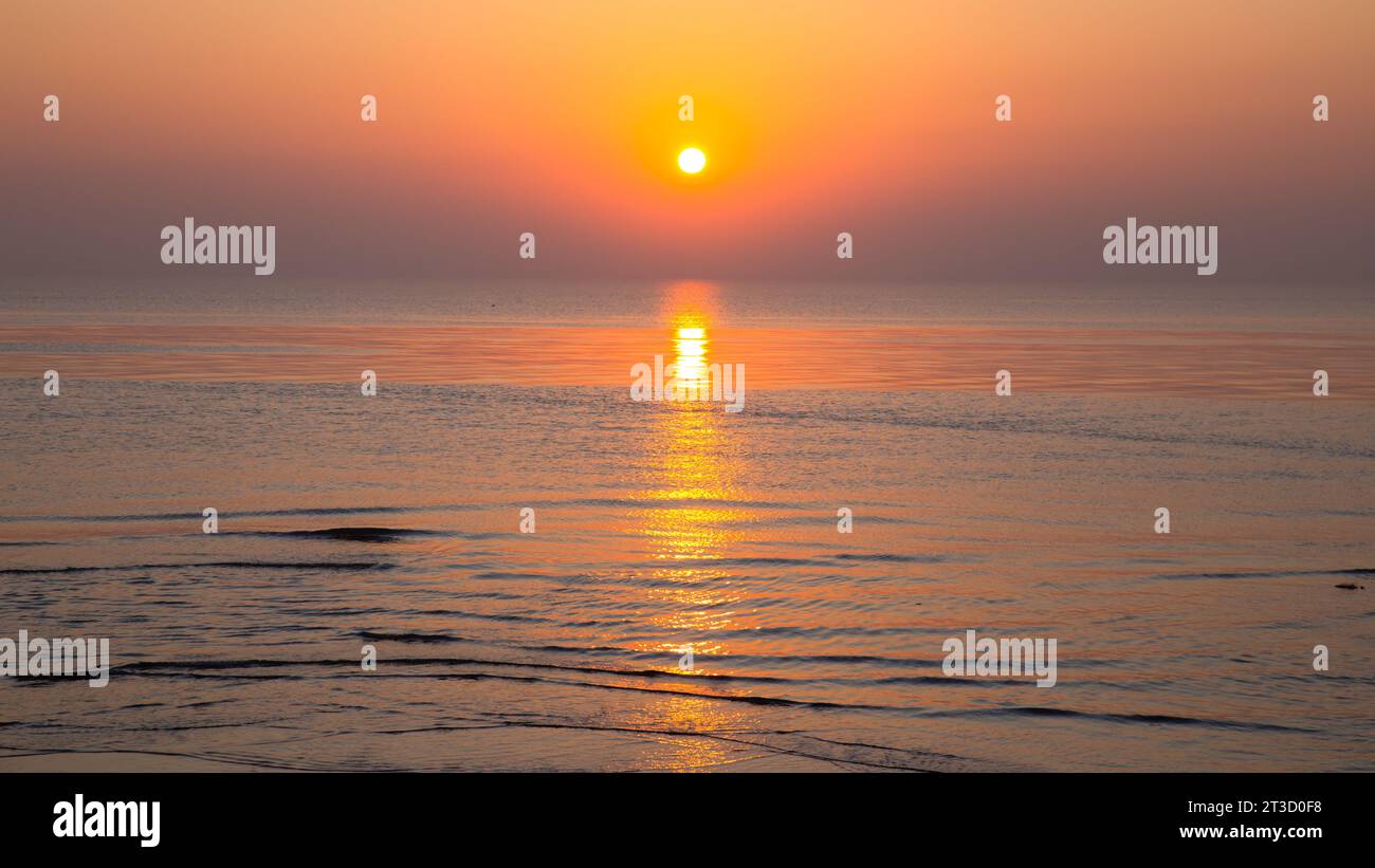 coucher de soleil sur la mer avec des vagues vives et reflet dans l'eau Banque D'Images